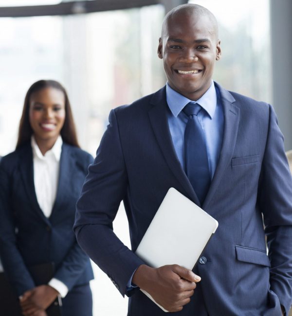 handsome african businessman with group of businesspeople on background
